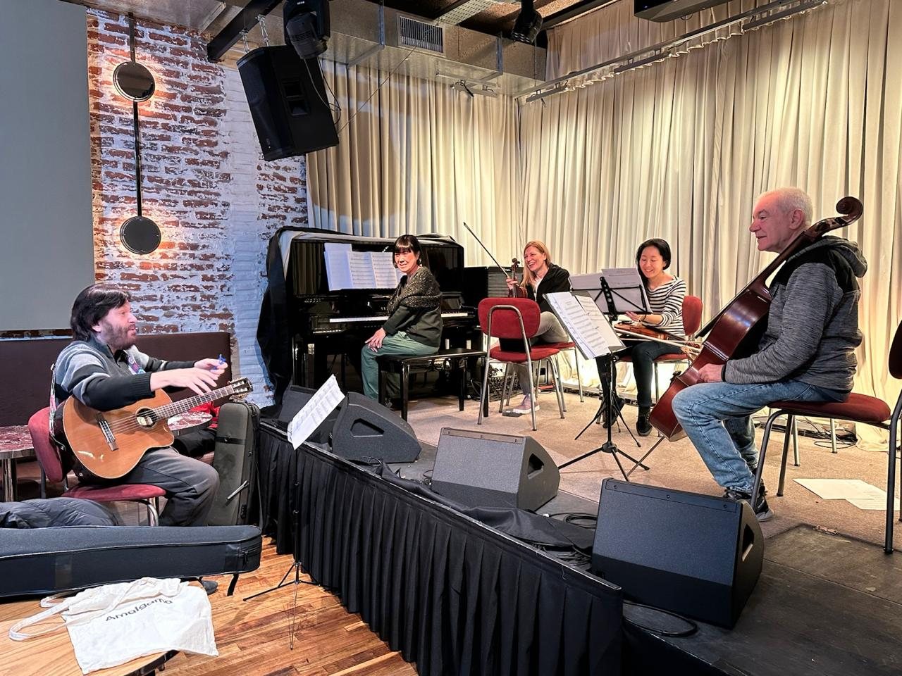 Ensayo de X-Strings, guitarra y piano en primer plano
